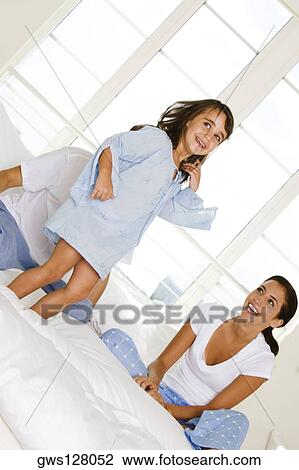Girl standing on the bed in front of her parents View Large Photo Image Stock Image - Girl standing on the bed in front of her parents. Fotosearch