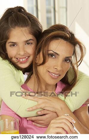 Portrait of a girl hugging her mother View Large Photo Image Picture - Portrait of a girl hugging her mother. Fotosearch