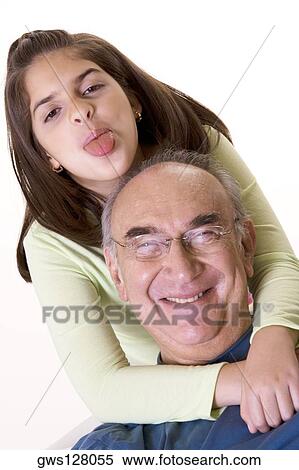 Portrait of a granddaughter sticking out her tongue and hugging her grandfather View Large Photo Image Stock Photography - Portrait of a granddaughter sticking out her tongue and hugging her grandfather. Fotosearch