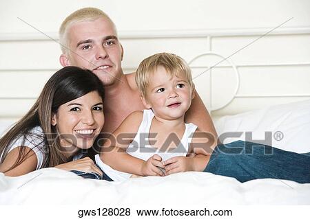 Portrait of parents and their son on a bed View Large Photo Image Stock Photo - Portrait of parents and their son on a bed. Fotosearch
