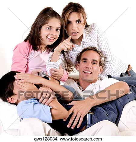 Portrait of parents watching television with their son and daughter View Large Photo Image Picture - Portrait of parents watching television with their son and daughter. Fotosearch
