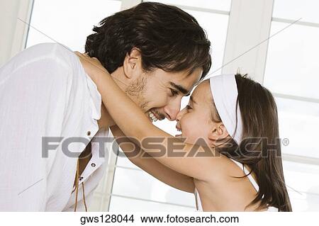 Side profile of a father looking at his daughter View Large Photo Image Picture - Side profile of a father looking at his daughter. Fotosearch