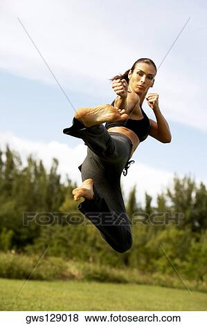 Low angle view of a mid adult woman practicing martial arts View Large Photo Image Stock Photo - Low angle view of a mid adult woman practicing martial arts. Fotosearch