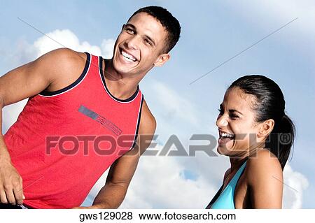 Low angle view of a young couple laughing View Large Photo Image Stock Photo - Low angle view of a young couple laughing. Fotosearch