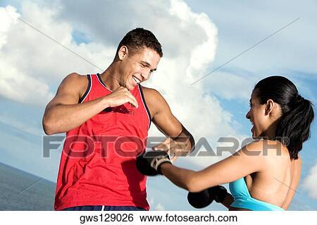 Stock Photograph - Low angle view of a young couple sparring. Fotosearch