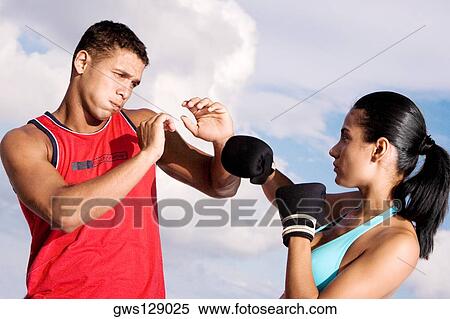 Low angle view of a young couple sparring View Large Photo Image Stock Photography - Low angle view of a young couple sparring. Fotosearch