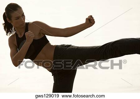 Stock Photo - Mid adult woman practicing martial arts. Fotosearch