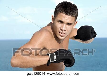 Portrait of a young man wearing boxing gloves View Large Photo Image Picture - Portrait of a young man wearing boxing gloves. Fotosearch