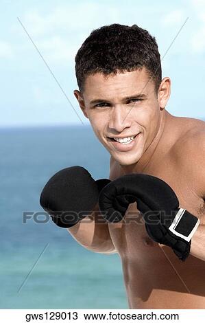 Portrait of a young man wearing boxing gloves View Large Photo Image Stock Image - Portrait of a young man wearing boxing gloves. Fotosearch
