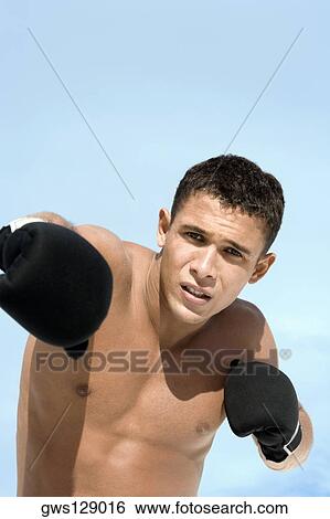 Portrait of a young man wearing boxing gloves View Large Photo Image Stock Photograph - Portrait of a young man wearing boxing gloves. Fotosearch