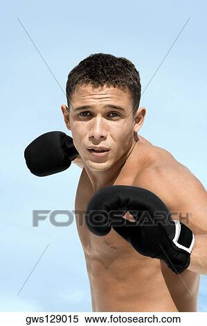 Stock Photography - Portrait of a young man wearing boxing gloves. Fotosearch