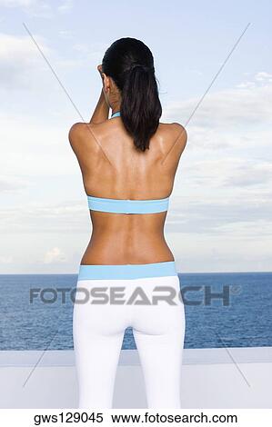 Stock Photography - Rear view of a young woman exercising. Fotosearch