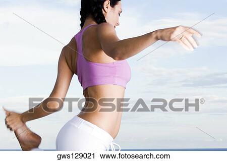 Side profile of a young woman standing on one leg View Large Photo Image Stock Image - Side profile of a young woman standing on one leg. Fotosearch