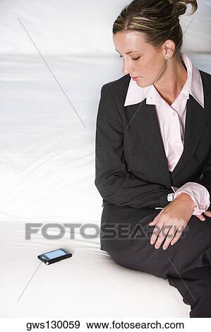 High angle view of a businesswoman looking at a mobile phone View Large Photo Image Stock Photo - High angle view of a businesswoman looking at a mobile phone. Fotosearch