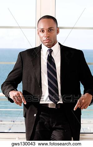 Stock Image - Portrait of a businessman leaning against a railing. Fotosearch