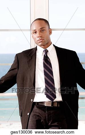 Stock Photograph - Portrait of a businessman leaning against a railing. Fotosearch