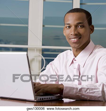 Stock Photograph - Portrait of a businessman using a laptop. Fotosearch