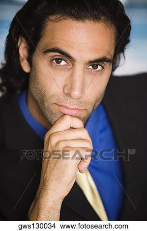 Picture - Portrait of a businessman with his hand on his chin. Fotosearch