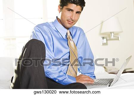 Stock Image - Portrait of a businessman working on a laptop. Fotosearch