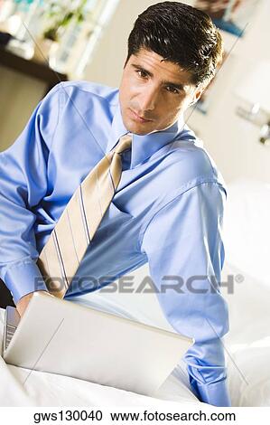Portrait of a businessman working on a laptop View Large Photo Image Stock Image - Portrait of a businessman working on a laptop. Fotosearch