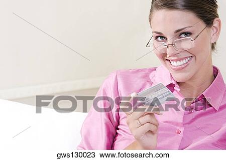 Portrait of a young woman holding a credit card View Large Photo Image Stock Image - Portrait of a young woman holding a credit card. Fotosearch