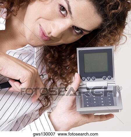 Portrait of a young woman holding a calculator View Large Photo Image Stock Photo - Portrait of a young woman holding a calculator. Fotosearch