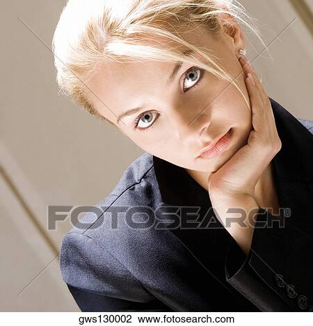 Stock Image - Portrait of a young woman with her hand on her chin. Fotosearch