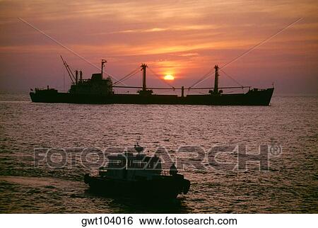 Freighter at sunset in the South China Sea, Vietnam View Large Photo Image Stock Photograph - Freighter at sunset in the South China Sea, Vietnam. Fotosearch