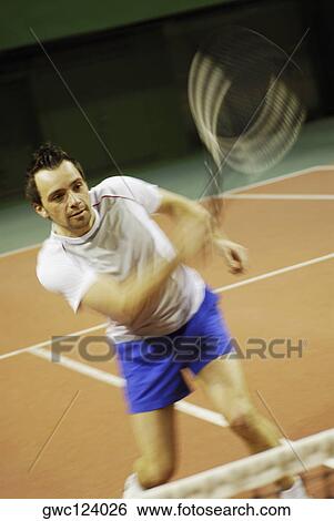 Close-up of a mid adult man playing tennis View Large Photo Image Stock Photograph - Close-up of a mid adult man playing tennis. Fotosearch