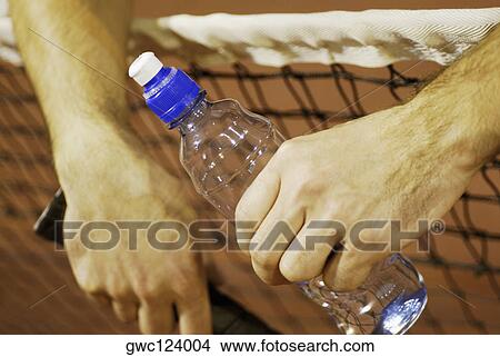 Close-up of a person's hand holding a water bottle View Large Photo Image Picture - Close-up of a person's hand holding a water bottle. Fotosearch