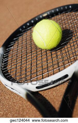 Picture - Close-up of a tennis ball on a tennis racket. Fotosearch