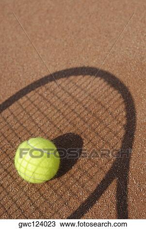 Stock Image - Close-up of a tennis ball on the shadow of a tennis racket. Fotosearch