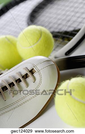 Stock Photo - Close-up of a tennis shoe with tennis balls and rackets. Fotosearch