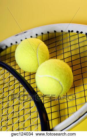 Picture - Close-up of two tennis balls on a tennis racket. Fotosearch