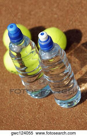 Stock Photography - High angle view of two water bottles with three tennis balls. Fotosearch