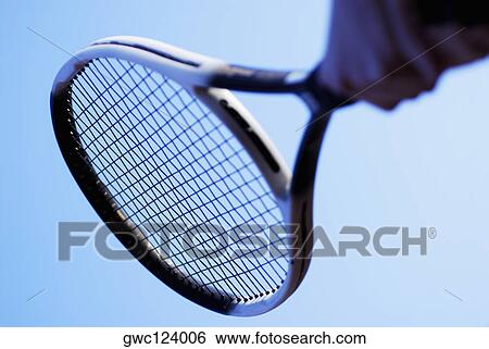 Stock Photograph - Low angle view of a person's hand holding a tennis racket. Fotosearch