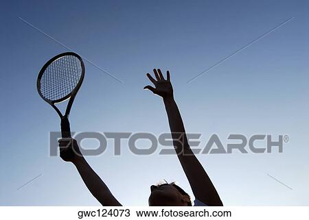 Low angle view of a young woman holding a tennis racket View Large Photo Image Stock Image - Low angle view of a young woman holding a tennis racket. Fotosearch