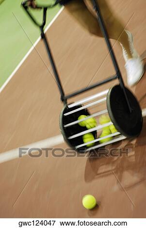 Low section view of a person walking with a roller hopper tennis ball carrier View Large Photo Image Stock Photo - Low section view of a person walking with a roller hopper tennis ball carrier. Fotosearch