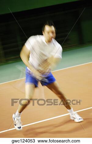 Mid adult man playing tennis View Large Photo Image Stock Image - Mid adult man playing tennis. Fotosearch