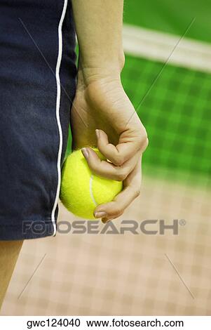 Mid section view of a Woman holding a tennis ball View Large Photo Image Stock Image - Mid section view of a Woman holding a tennis ball. Fotosearch