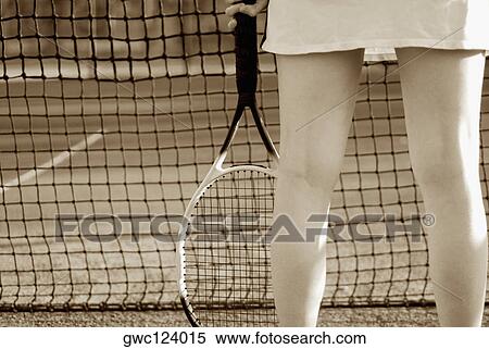 Stock Photography - Mid section view of a woman holding a tennis racket. Fotosearch