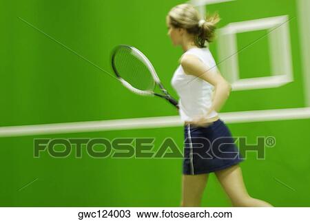 Side profile of a young woman playing tennis View Large Photo Image Stock Image - Side profile of a young woman playing tennis. Fotosearch