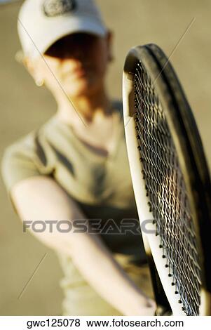 Close-up of a mid adult woman holding a tennis racket View Large Photo Image Stock Photo - Close-up of a mid adult woman holding a tennis racket. Fotosearch