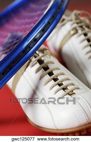 Close-up of a pair of sports shoes and a tennis racket View Large Photo Image Stock Photo - Close-up of a pair of sports shoes and a tennis racket. Fotosearch