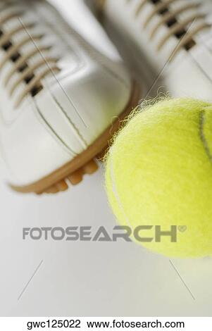 Close-up of a tennis ball and a pair of sports shoes View Large Photo Image Stock Image - Close-up of a tennis ball and a pair of sports shoes. Fotosearch
