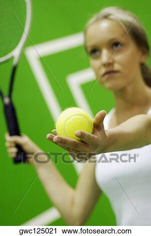 Close-up of a young woman holding a tennis racket and a tennis ball View Large Photo Image Stock Image - Close-up of a young woman holding a tennis racket and a tennis ball. Fotosearch