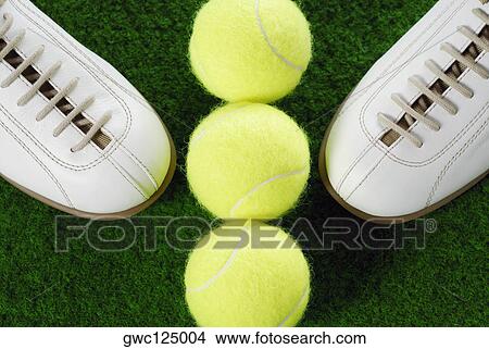 Picture - High angle view of a pair of sports shoes and three tennis balls. Fotosearch