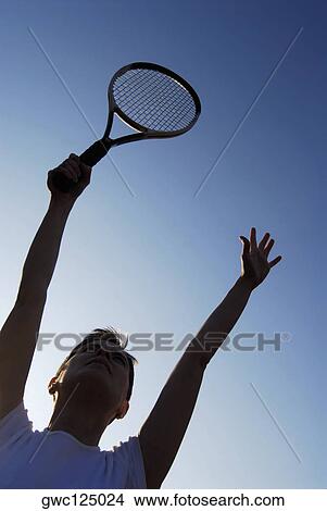 Low angle view of a mid adult woman holding a tennis racket View Large Photo Image Picture - Low angle view of a mid adult woman holding a tennis racket. Fotosearch