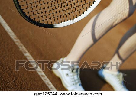 Low section view of a person standing on a tennis court View Large Photo Image Picture - Low section view of a person standing on a tennis court. Fotosearch