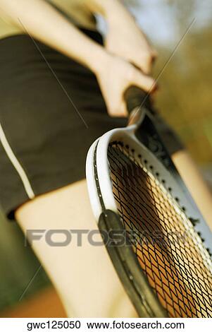 Mid section view of a woman holding a tennis racket View Large Photo Image Stock Image - Mid section view of a woman holding a tennis racket. Fotosearch